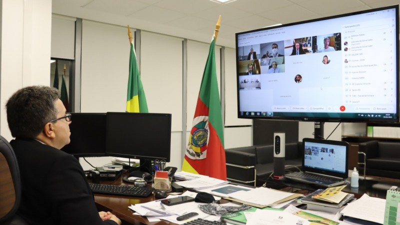 Foto de Antonio Flávio de Oliveira, acompanhando a reunião em um telão