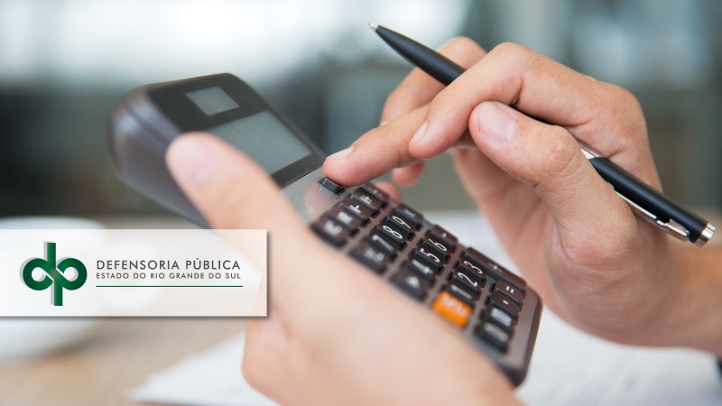 foto de uma mão, segurando uma caneta e utilizando uma calculadora, com a logomarca da Defensoria Pública 