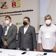 mesa de abertura, composta por autoridades, cantando o hino nacional