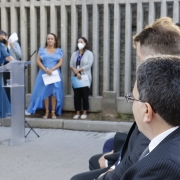 foto do Defensor público-geral do estado, Antonio Flávio de Oliveira, em primeiro plano, acompanhando o discurso de Heloisa Kuser, em segundo plano e desfocada