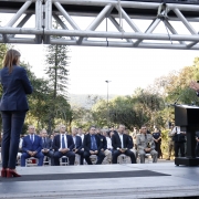 subchefe de polícia discursando no palco, com a chefe de polícia ao lado e o público acompanhando