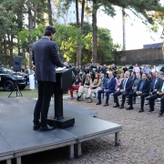 cerimonialista, em primeiro plano e de costas, anunciando os participantes