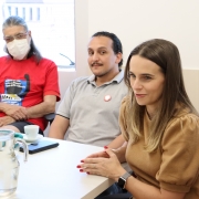 defensora pública conversando com os representantes, em primeiro plano, e em segundo plano, dois homens