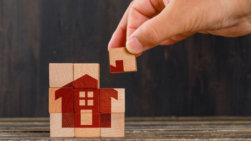 stay at home concept on wooden table side view hand holding wooden cube