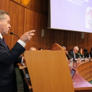em primeiro plano e a esquerda, o presidente do TCERS, alexandre postal, discursa. Ao fundo, os integrantes da mesa de abertura, desfocados