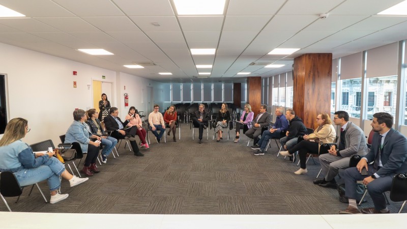 foto geral e aberta do auditório da defensoria, onde os 16 participantes do encontro sentaram em meia lua