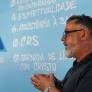 recuperando explica o funcionamento do presídio. mural com as bases das APACs ao fundo.