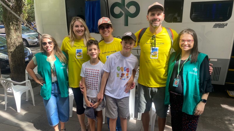 Servidoras, defensora e família posam para foto em frente à unidade móvel da DPE.