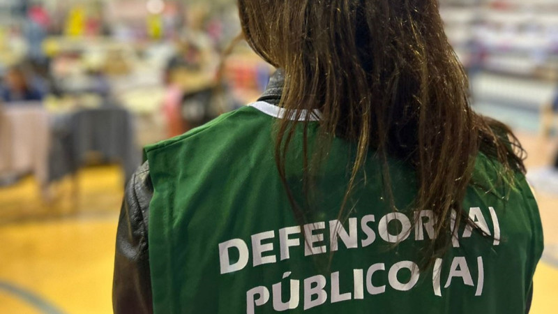 Defensora pública de costas observando abrigo.