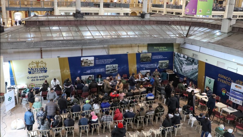 Foto mostra diversas pessoas aguardando atendimento da Defensoria Pública em mutirão no Mercado Público