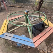 foto de um brinquedo gira gira cheio de terra e quebrado