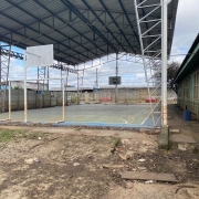 foto da quadra poliesportiva quebrada e cheia de terra após a inundação 