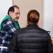 Foto geral de um defensor público conversando com um assistido de costas