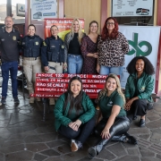 Dois homens e oito mulheres em torno do Banco Vermelho. Imagem ilustra integrantes da ação na Rodoviária de Porto Alegre.