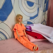 foto de uma boneca usando macacão laranja
