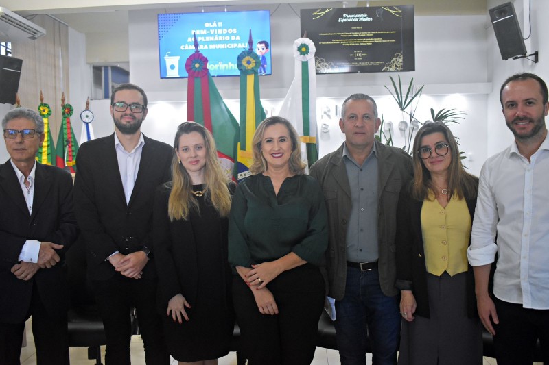 7 adultos em uma sala, todos de pé e um do lado do outro, posando para a foto.