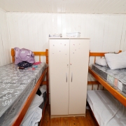 foto de outro quarto, com dois beliches, um de cada lado do recinto, e um armário no meio deles