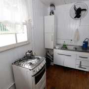 foto da cozinha da casa, com uma pia, um fogão de 4 bocas e poucos armários