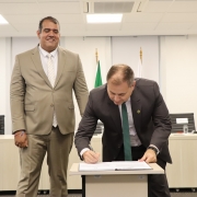 foto do defensor geral assinando a posse do ouvidor, que acompanha ao lado, em pé