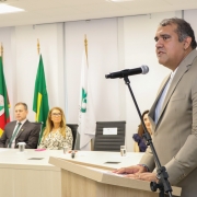 foto do ouvidor em primeiro plano, discursando, e a mesa de autoridades ao fundo