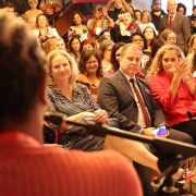 foto da representante do Internacional discursando, desfocada em primeiro plano e de costas. no segundo plano e focado, está o público e o defensor público geral