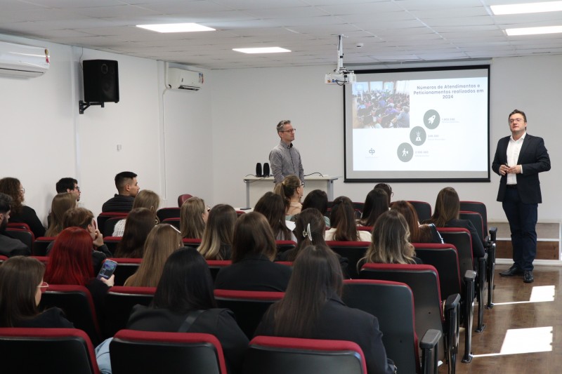 Na foto, os defensores Rafael Pedro Magagnin e Renato Muñoz de Oliveira Santos realizam palestra para alunos da universidade.