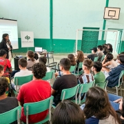 foto da psicóloga falando e os alunos de costas ouvindo