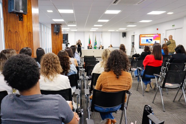 Público reunido assistindo a uma palestra no auditório da Defensoria Pública