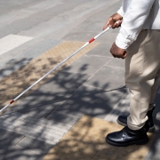 Homem com deficiência visual atravessando a rua