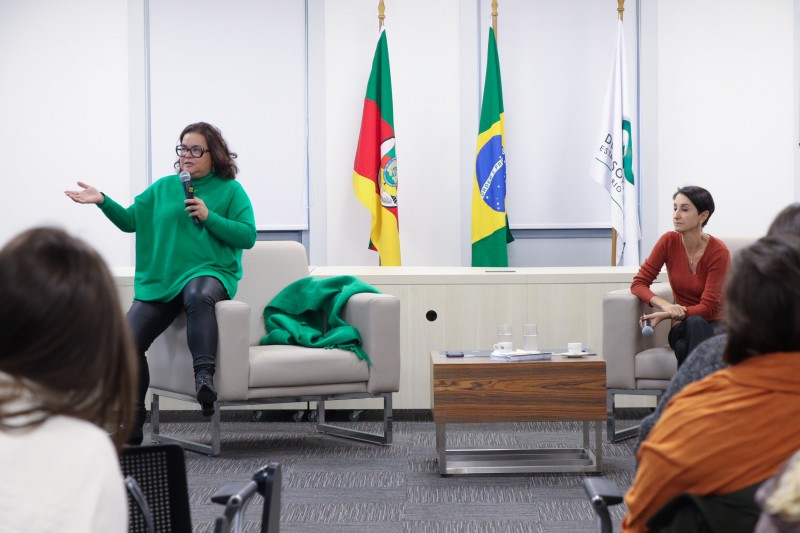 Duas psicólogas ministrando uma oficina sobre autismo no auditório.