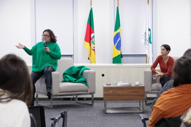 Duas psicólogas ministrando uma oficina sobre autismo no auditório.