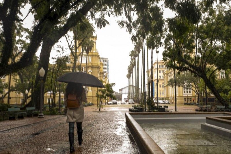 Mulher caminhando com um guarda-chuva por Porto Alegre