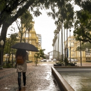 Mulher caminhando com um guarda-chuva por Porto Alegre