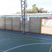 Na foto, vemos o muro da quadra da escola.
