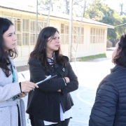 Na foto, vemos a defensora e uma servidora conversando com uma das responsáveis pela escola.