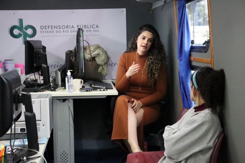 Defensora prestando orienta&ccedil;&atilde;o a uma mulher dentro da unidade m&oacute;vel da Defensoria