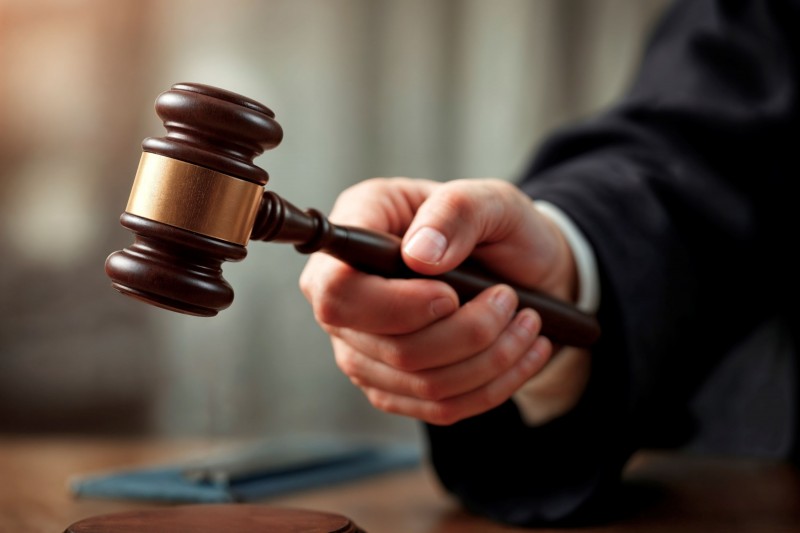 Pessoa segurando um martelo de madeira