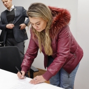 Dirigente do NUDEM, Paula Britto Granetto, assinando o termo.