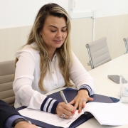 Paula assina o termo.