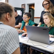 foto de duas servidoras e uma defensora, de frente, atendendo uma mulher que está se costas
