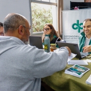 foto de dois defensores, de frente, atendendo um casal de moradores