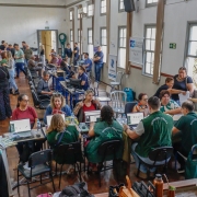 foto do auditório lotado de pessoas e a equipe da defensoria atendendo