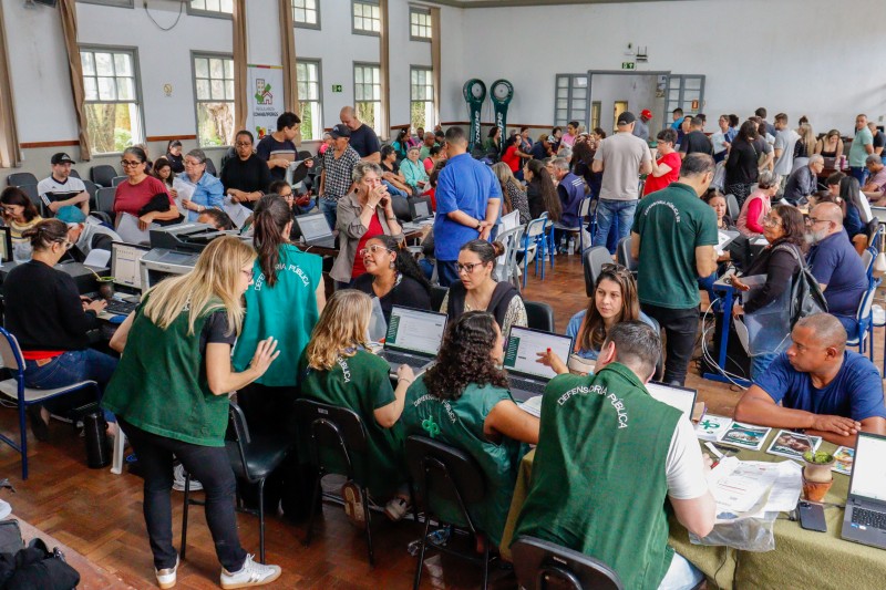 foto do audit&oacute;rio cheio de pessoas e a equipe da defensoria atendendo