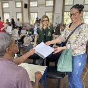 foto de uma mulher recebendo a documentação regularizada do seu imóvel