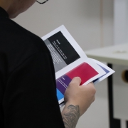 Homem segurando cartilha de educação em direitos da Defensoria