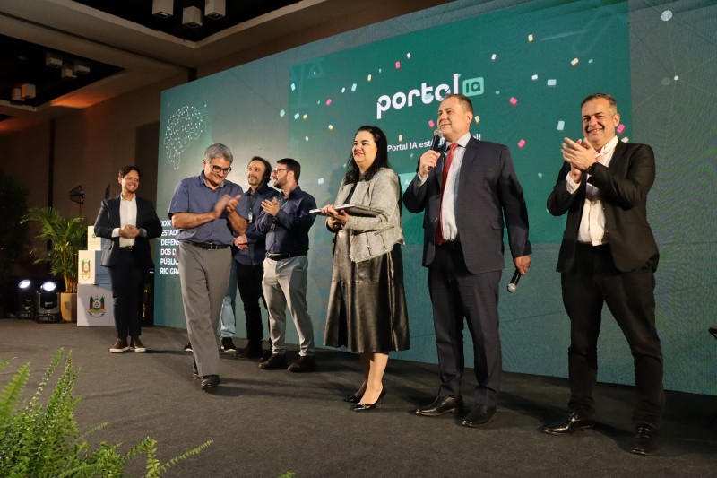 A imagem mostra os servidores da DPE no palco do evento.