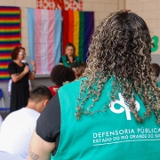 Servidora da dpe assiste cerimônia.