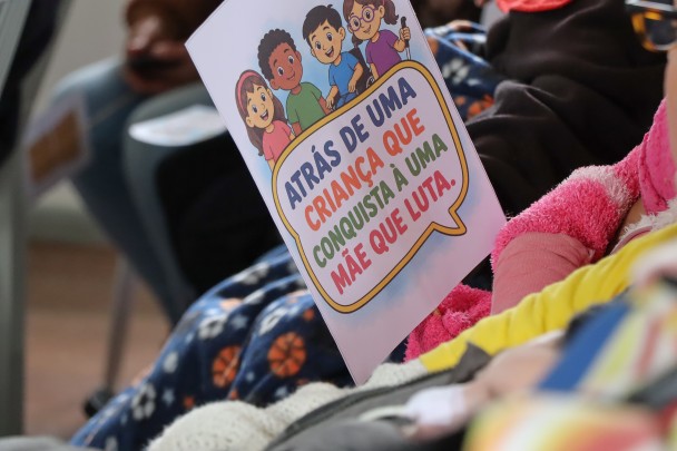 criança segura um cartaz em que diz atrás de uma criança que conquista há uma mãe que luta
