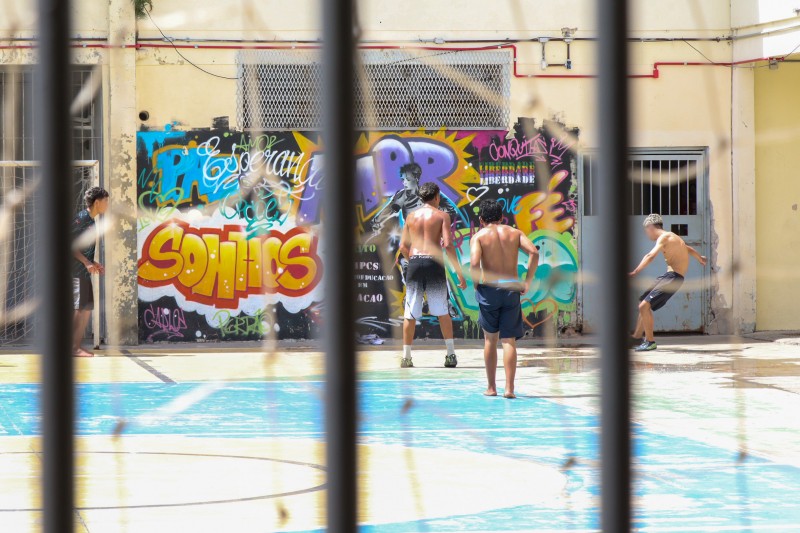 Adolescentes jogam futebol.
